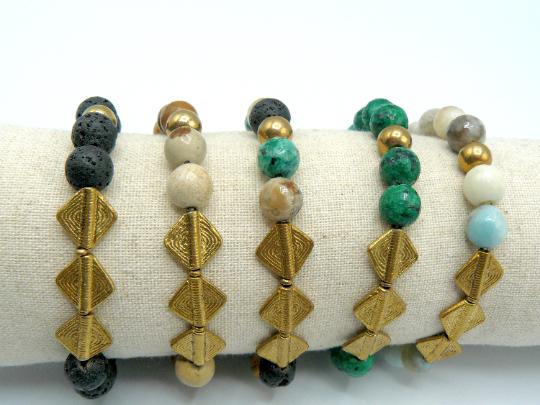 Four Men's Bracelets with Natural semi precious stones set on a strong and durable elastic band with rhomubs shaped matte gold plated brass garnishments. One of the Bracelets has Black Stones. Another, White Stones. A Third Has Brown Stones. Another has Green Ones and The Last One, Multicolor Stones.