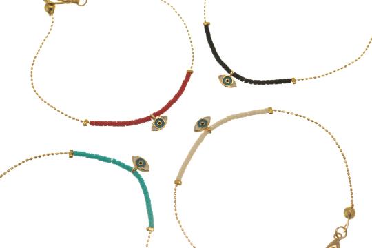 Four Gold-Plated Brass Thin Chain Bracelets With Lobster Clasp Adjustable Closure and Different Bead Colors: One With Black Beads, Another With White Beads, a Third With Turquoise Beads, and the Last One With Red Beads. The Central Piece of Each Bracelet is an Eye of Horus Charm and is Encased in a Layer of Gold Plated Brass
