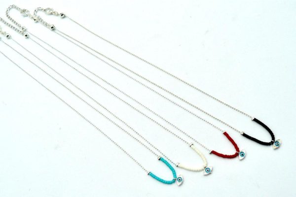 Four Silver-Plated Brass Thin Chain Necklaces With Lobster Clasp Adjustable Closure and Different Bead Colors: One With Black Beads, Another With White Beads, a Third With Turquoise Beads, and the Last One With Red Beads. The Central Piece of Each Necklace is an Eye of Horus Charm and is Encased in a Layer of Silver Plated Brass